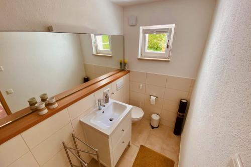 a white bathroom with a sink and a mirror at Ferienwohnung Zum Drachenstich in Murnau am Staffelsee