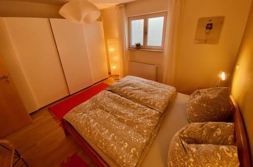 a small bedroom with two beds and a window at Ferienwohnung Zum Drachenstich in Murnau am Staffelsee