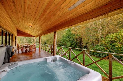 雷雅特的住宿－Rhosllyn Retreats - Lakeside Lodge，房屋甲板上的热水浴池