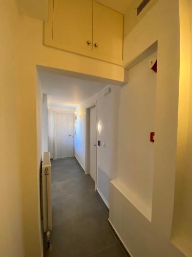 an empty hallway with a white wall and a door at Marousos Central Guesthouse in Portariá