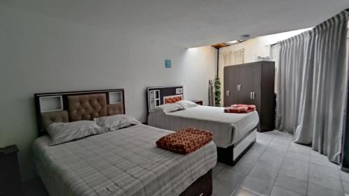 a bedroom with two beds and a chair in it at Departamento amplio y bonito en Arequipa 1er Piso in Arequipa
