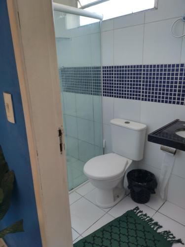 a bathroom with a toilet and a glass shower at Casa de praia para temporada in Paulista