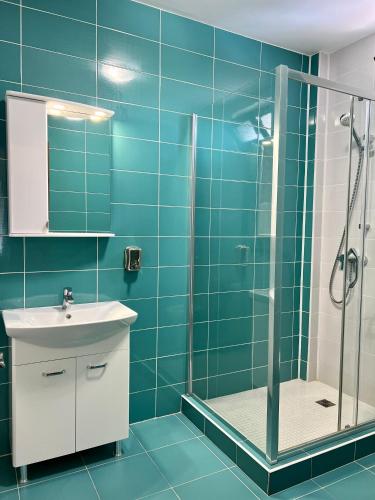 a blue bathroom with a shower and a sink at ARMONIA in Filiaşi