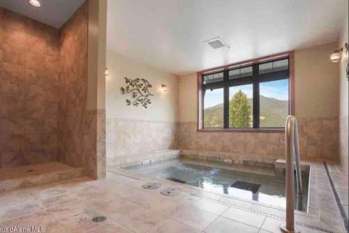 un ampio bagno con vasca e finestra di Penthouse Mountain Haven with Community Spa Room a Kellogg