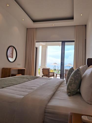 Aryan Beach Villa في وادوا: غرفة نوم بسرير كبير مع نافذة كبيرة
