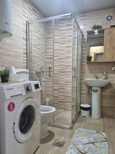 een badkamer met een wasmachine en een toilet bij Golden Sun Skopje in Skopje