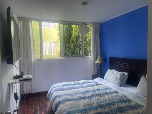 a blue bedroom with a bed and a window at Miraflores dpto 3 dormitorios in Lima