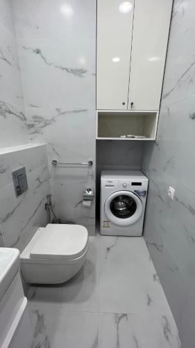 La salle de bains blanche est pourvue de toilettes et d'un lave-linge. dans l'établissement King Davit White, à Tbilissi