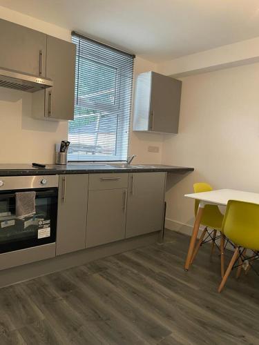 a kitchen with a counter and a table with chairs at Amazing Studio Room 3 - Chingford/NE London in Woodford