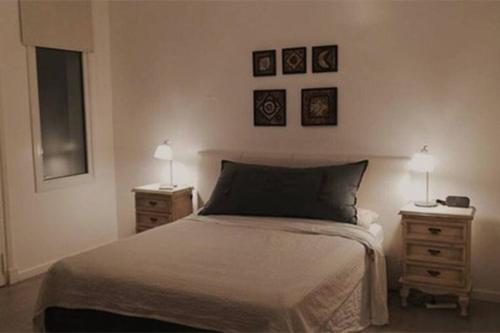 1 dormitorio con 1 cama y 2 mesitas de noche con 2 lámparas en Palermo Apartment en Buenos Aires