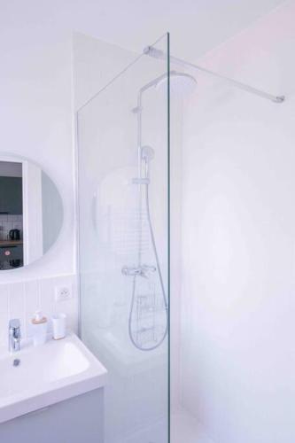 une salle de bain blanche avec une douche et un lavabo dans l'établissement Le Rêveur - Parking Gratuit, Wifi, RER C Choisy-le-Roi, à Choisy-le-Roi