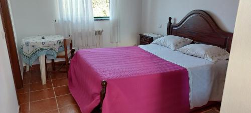 a bedroom with a bed with a pink blanket at Alojamento da Avó Maria in Pombal