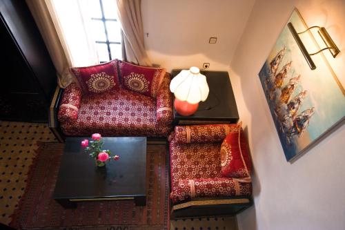 a living room with a chair and a table at Riad Maison Du Sud in Essaouira