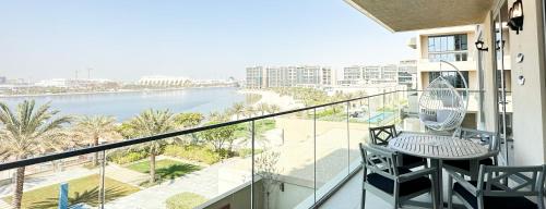 balcón con mesa, sillas y vistas al océano en Paradis De La Mer Al Zeina 507A1, en Abu Dabi