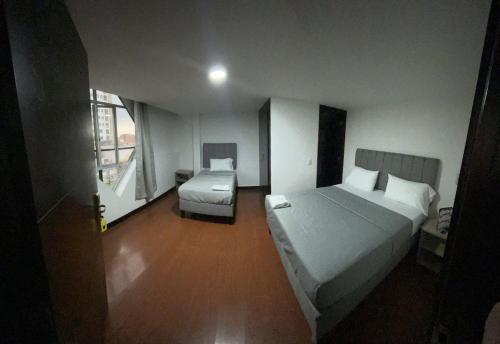 a hotel room with two beds and a window at Hotel The MIRROR in Bogotá