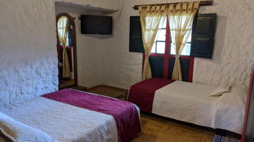 a bedroom with two beds and a window at POSADA AQUILINO in Cucunubá