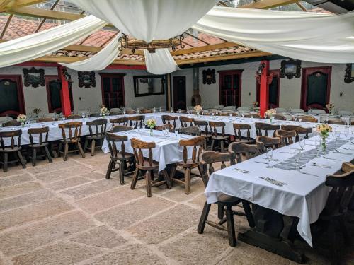 a large room with tables and chairs with white tablecloths at POSADA AQUILINO in Cucunubá