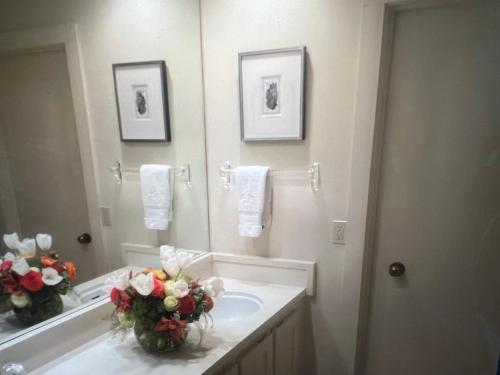 bagno con lavandino, specchio e fiori di SV Wildflower Condo 3 Bed 3 Bath w SV INN pool access- No PETS! a Sun Valley