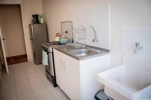 a kitchen with a sink and a refrigerator at Vive Piura a tu manera in Piura