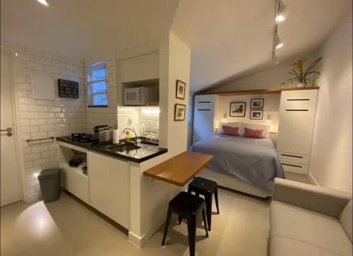 a small bedroom with a bed and a kitchen at STUDIO MONSIEUR 421 LEBLoN in Rio de Janeiro