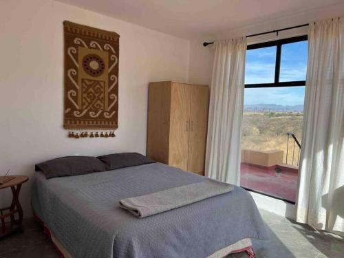 een slaapkamer met een bed en een groot raam bij Casa en las montañas de San Miguel de Allende in San Miguel de Allende