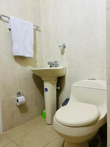a bathroom with a white toilet and a sink at Apartamento Santa marta el rodadero in Gaira