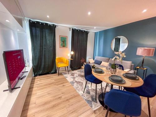 uma sala de estar com uma mesa e cadeiras azuis em Appartement cosy Paris métro 9 pour 10 em Montreuil