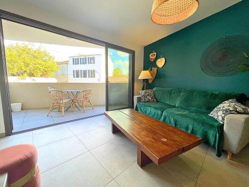 ein Wohnzimmer mit einem grünen Sofa und einem Tisch in der Unterkunft *Le Royal*Havre De Paix*Wifi* in Marseille