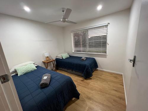 a bedroom with two beds and a window at CBR Equine Cottage in Amamoor