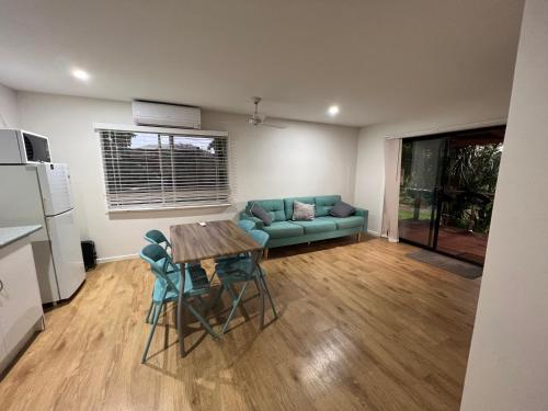 a living room with a blue couch and a table at CBR Equine Cottage in Amamoor