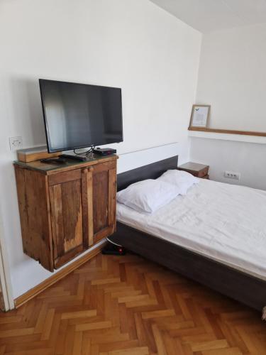 a bedroom with a bed and a flat screen tv at Blue New Yorker in Niš