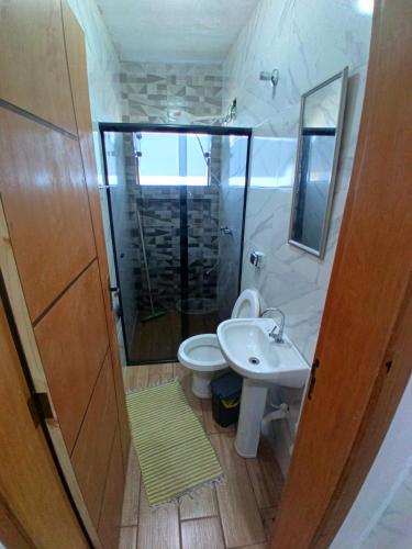 a bathroom with a toilet and a sink and a shower at Flat 02 com Varanda - Avenida Hospedagem in São Thomé das Letras