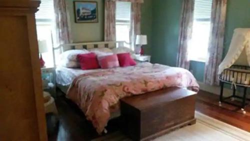 a bedroom with a large bed with red pillows at Gloucester House in Gloucester
