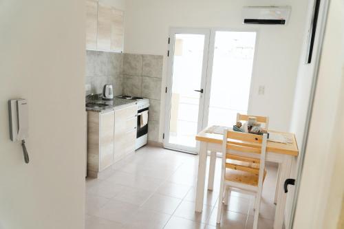 a small kitchen with a table and a stove at PINEDA DEL RIO in Patagones