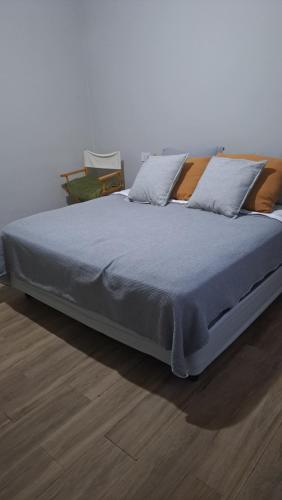 un grande letto con una coperta blu su un pavimento in legno di Habitación en hermosa casa de descanso a Laguna Brava