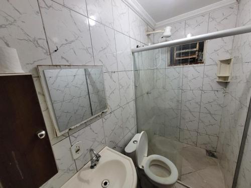 La salle de bains est pourvue de toilettes, d'un lavabo et d'un miroir. dans l'établissement Apartamento 302 maravilhoso e espaçoso, à Brasilia