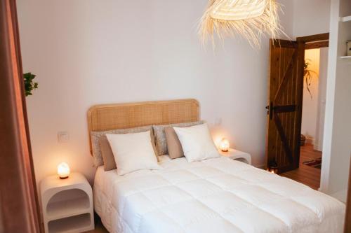 - une chambre avec un grand lit blanc et deux lampes dans l'établissement Casa Taray, 