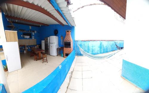 una cocina con paredes azules y una hamaca en Peruíbe casa 150 metros praia 3 dormitórios casa independente en Peruíbe
