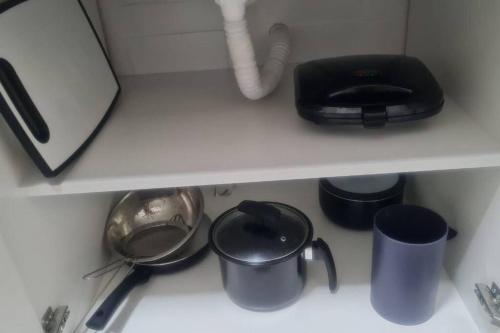 a kitchen counter with pots and pans on a shelf at Cabo Frio - Temporadas in Cabo Frio