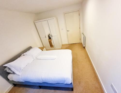 a small bedroom with a white bed and a closet at Your Riverside Home 3 with Private balcony in Woolwich