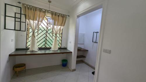 um quarto com uma janela e uma mesa com uma janela em BabaJay Family Home em Dar es Salaam