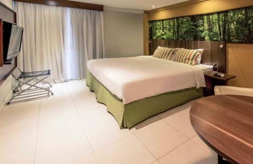 sypialnia z dużym łóżkiem i stołem w obiekcie Flat em hotel Mercure w mieście Nova Iguaçu