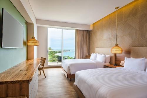 a hotel room with two beds and a window at Santa Marta Marriott Resort Playa Dormida in Santa Marta