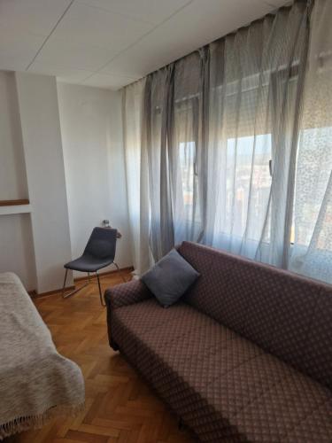 a living room with a couch and a window at Blue New Yorker in Niš