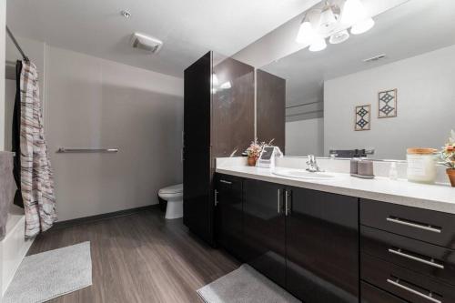 ein Badezimmer mit einem Waschbecken, einem WC und einem Spiegel in der Unterkunft Private, Modern Luxury 2 Bd/ 2 Ba in Santa Ana