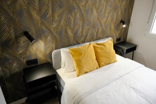 a bedroom with a bed with two yellow pillows at Urban Oasis La Palma in Santa Cruz de la Palma
