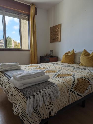 a bedroom with a bed with towels on it at Pine Tree Apartment in Porto