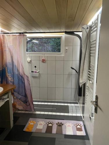a bathroom with a shower with a tile floor at Studio famille, lit aventurier in Saint-Laurent-de-Neste