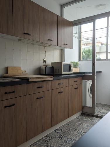 a kitchen with wooden cabinets and a microwave at Pine Tree Apartment in Porto