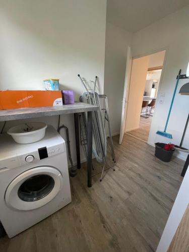 a laundry room with a washing machine and a table at Le Porge Location neuve à 10 mn de l’océan in Le Porge